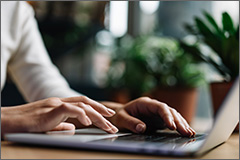 Woman with hands on a laptop